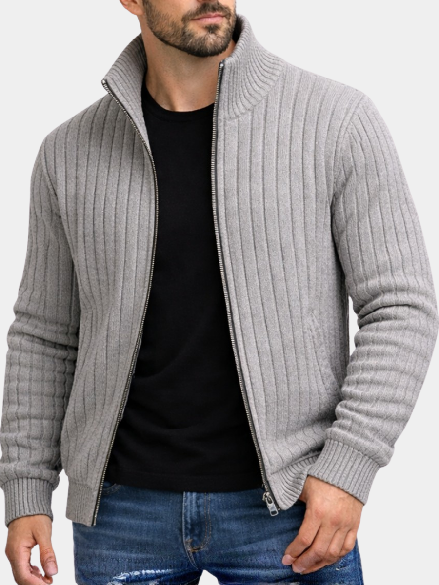 Graue Herren-Strickjacke mit Reißverschluss, Stehkragen und geripptem Strickmuster über einem schwarzen T-Shirt.