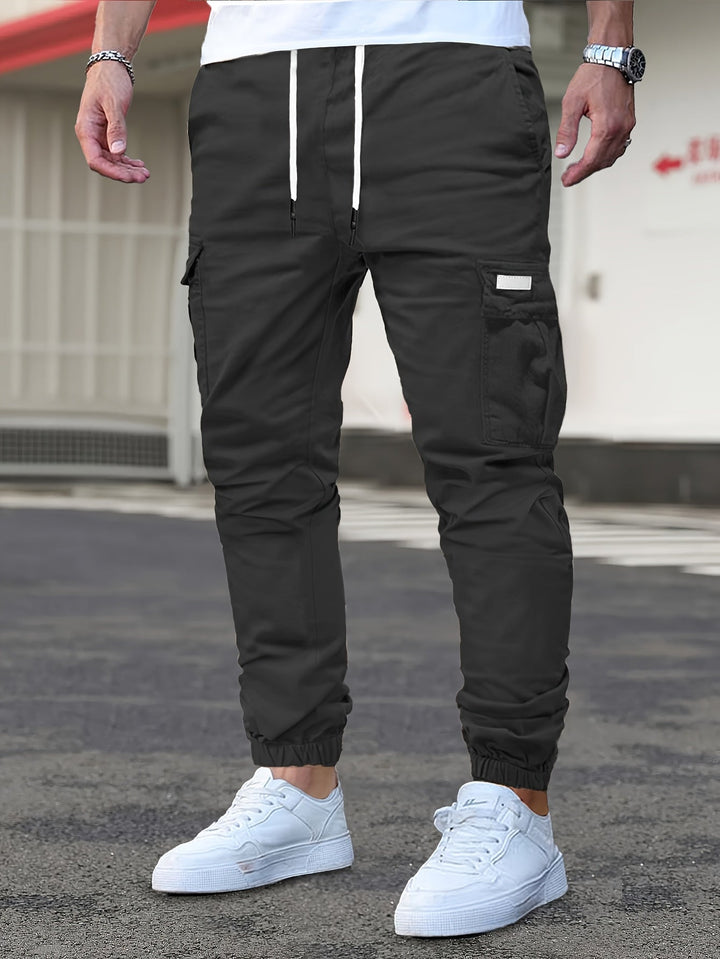 Schwarze Herren-Cargohose mit Kordelzug, seitlichen Taschen und elastischen Beinbündchen im modernen Jogger-Stil.