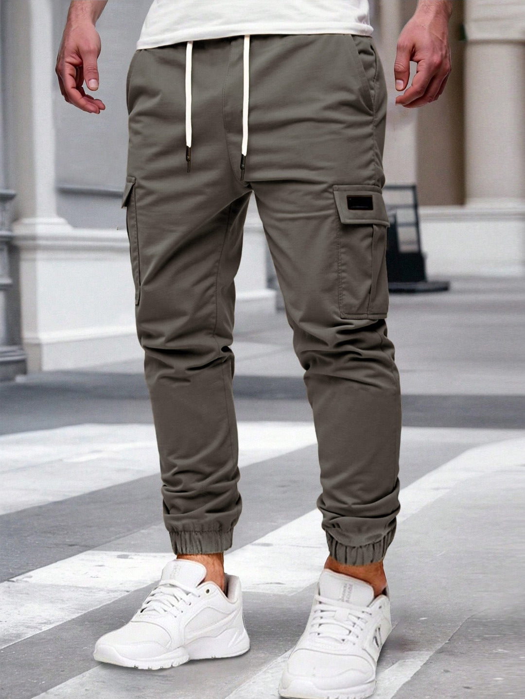 Olivgrüne Herren-Cargohose mit Kordelzug, seitlichen Taschen und elastischen Beinbündchen im modernen Jogger-Stil.