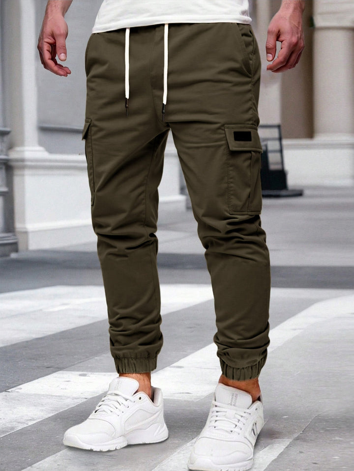Olivgrüne Herren-Cargohose mit Kordelzug, seitlichen Taschen und elastischen Beinbündchen im modernen Jogger-Stil.