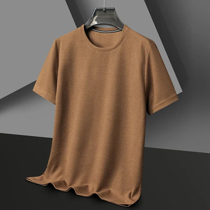 Braunes Herren-T-Shirt mit Waffelstrick-Struktur, Rundhalsausschnitt und lockerer Passform auf einem Kleiderbügel.