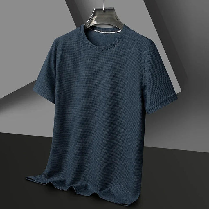 Dunkelblaues Herren-T-Shirt mit Waffelstrick-Struktur, Rundhalsausschnitt und lockerer Passform auf einem Kleiderbügel.