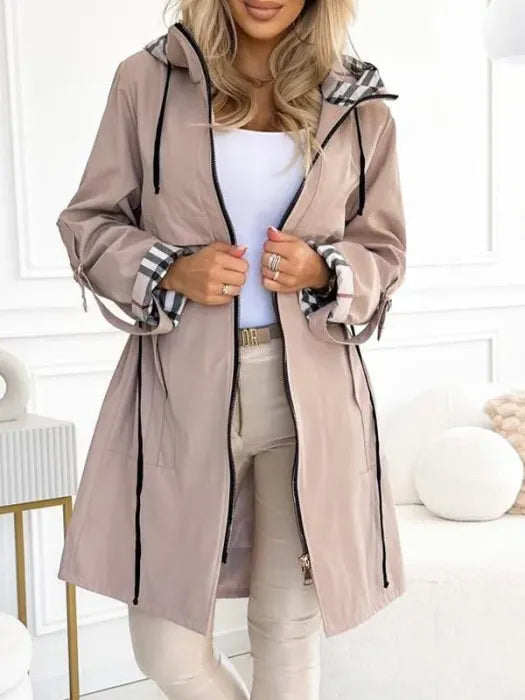 Beigefarbene Damen-Kapuzenjacke mit Reißverschluss, Taillenkordelzug und kariertem Innenfutter an Kapuze und Ärmeln.