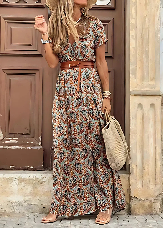 Langes Boho-Maxikleid mit V-Ausschnitt, buntem Paisley-Muster, kurzem Ärmel und seitlichem Schlitz, kombiniert mit Ledergürtel.