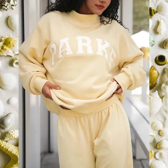 Cremefarbener Oversized-Pullover mit weißem Schriftzug-Print und weichem Material für einen lässigen Wohlfühl-Look.