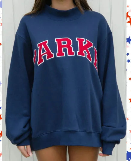 Dunkelblauer Oversized-Pullover mit Stehkragen und rotem Schriftzug-Print auf der Vorderseite.