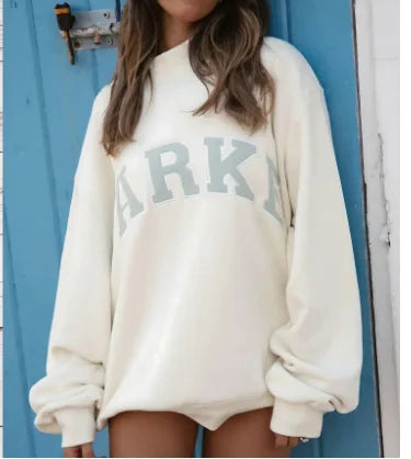 Cremefarbener Oversized-Pullover mit hellgrünem Schriftzug-Print und gemütlicher Passform.