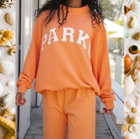 Oversized Damen-Sweatshirt in Orange mit weißem „PARK“-Schriftzug und weichem Material für einen lässigen Look.