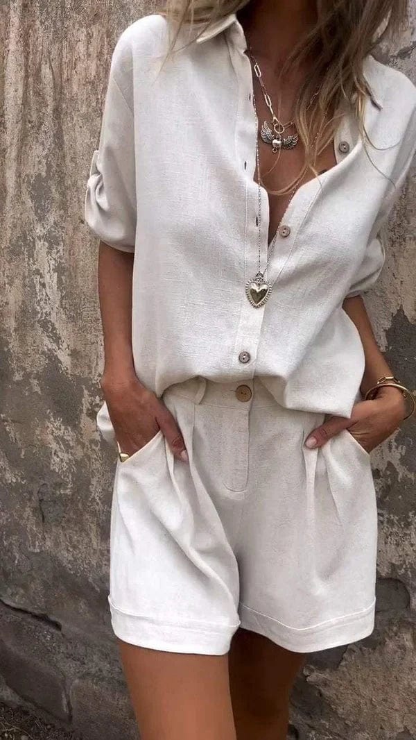 Beiger Damen-Zweiteiler in Leinenoptik mit kurzärmeliger Bluse, Knopfleiste und Shorts mit Seitentaschen.