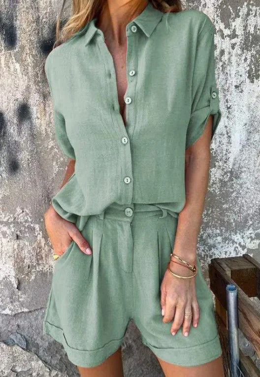 Salbeigrüner Damen-Zweiteiler aus Leinen mit kurzärmliger Bluse, Knopfleiste und lockeren Shorts mit Seitentaschen.