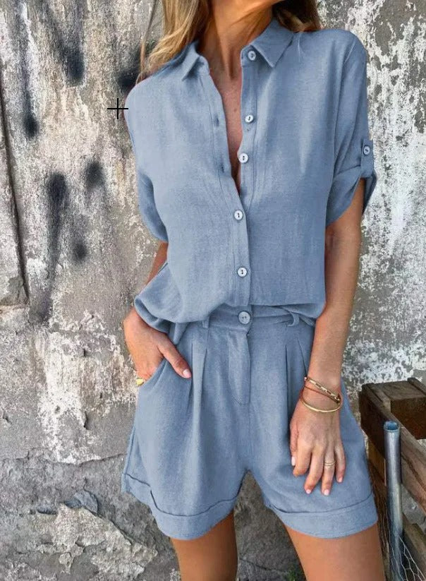 Hellblaues Damen-Zweiteiler-Set aus Leinen mit kurzärmliger Bluse, Knopfleiste und Shorts mit Seitentaschen.