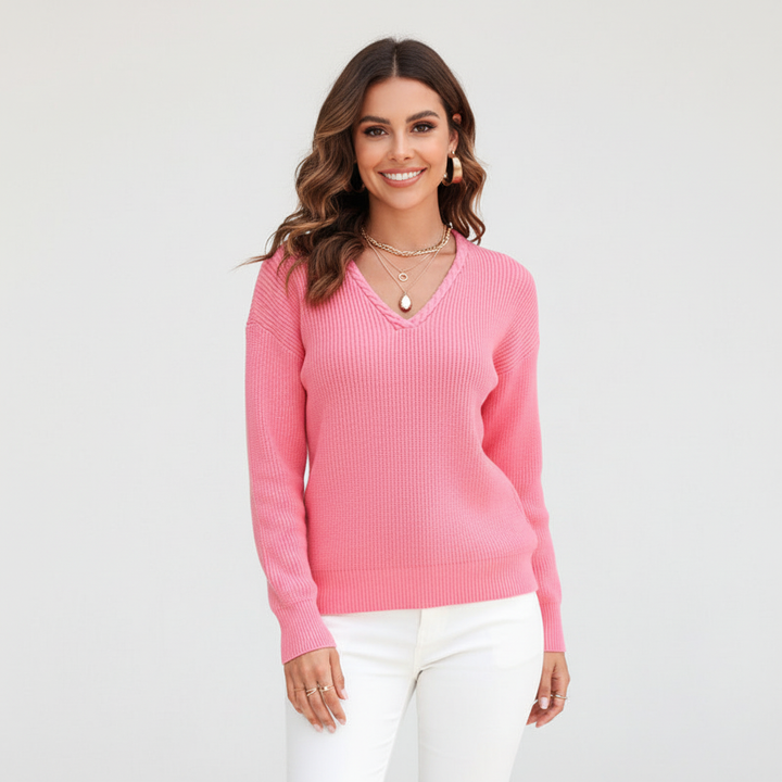 Kuscheliger pinker Damen-Strickpullover mit V-Ausschnitt, Zopfdetail und gerippter Struktur für einen eleganten Look.