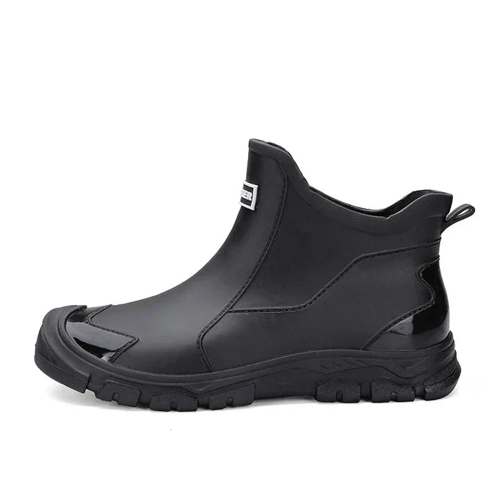Schwarze, wasserdichte Damen-Regenstiefeletten im Slip-on-Design mit robuster Profilsohle und verstärkter Zehenkappe.