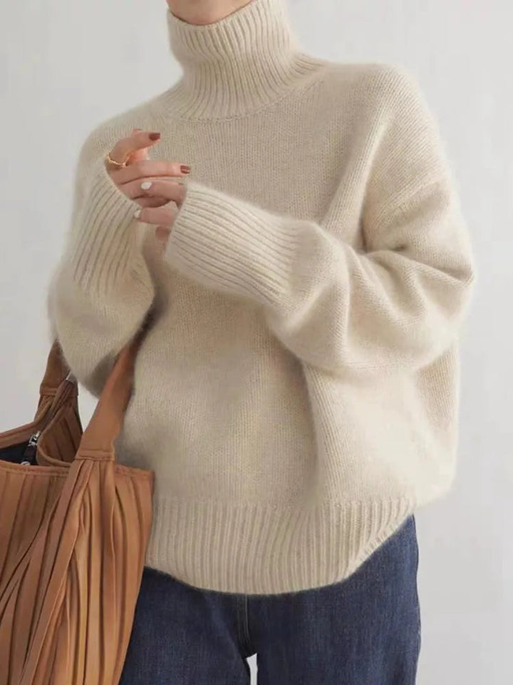 Beiger Oversized-Rollkragenpullover aus weichem Strick mit gerippten Bündchen für einen modernen, lässigen Look.