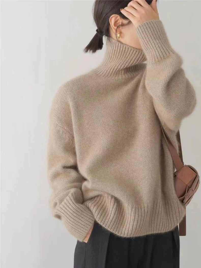 Beiger Oversized-Strickpullover mit hohem Rollkragen und gerippten Bündchen für einen modernen, gemütlichen Look.