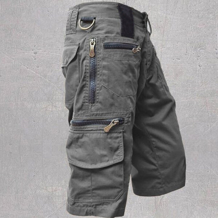 Dunkelgraue Silvan Cargo Shorts aus Baumwolle mit Reißverschlusstaschen, D-Ring und elastischem Bund für Outdoor-Aktivitäten.