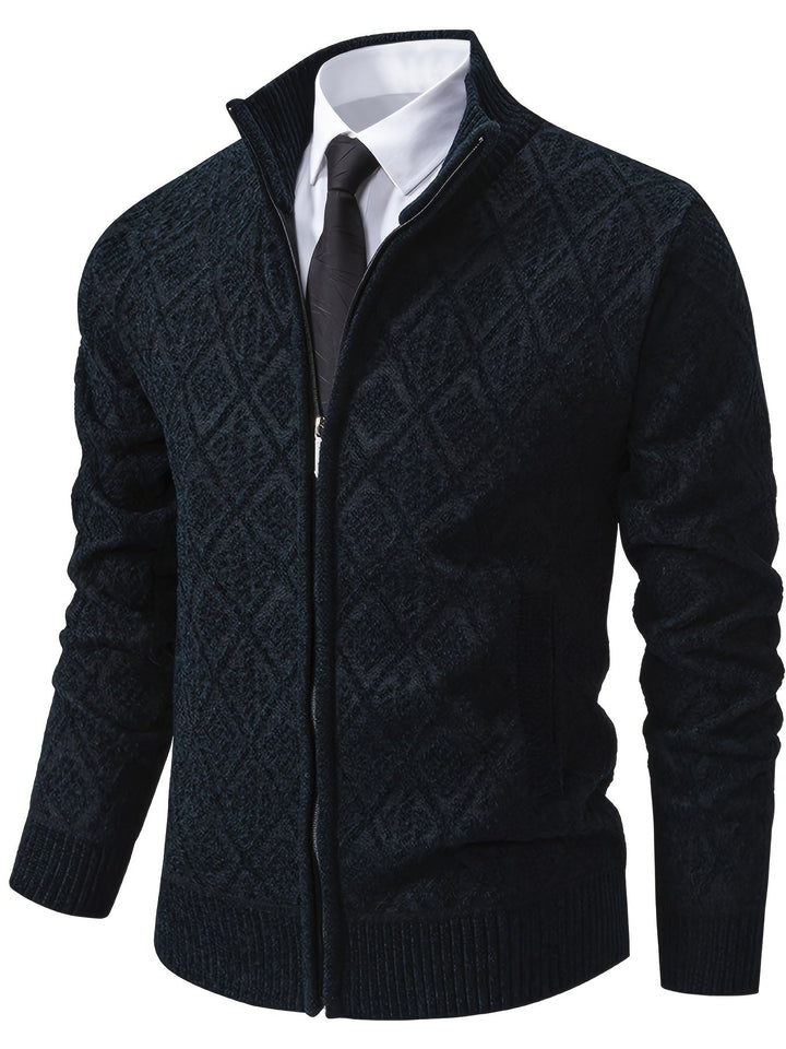 Dunkelblaue Herren-Strickjacke mit Rautenmuster, Stehkragen und durchgehendem Reißverschluss über weißem Hemd mit Krawatte.
