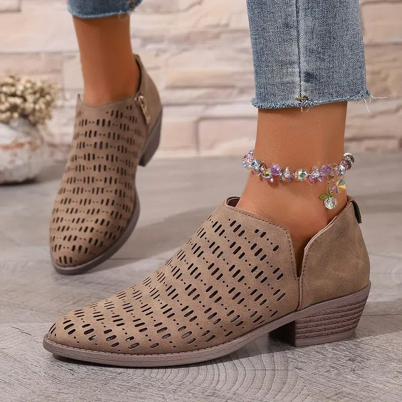 Beigefarbene Damen-Stiefeletten mit Cut-Out-Muster, seitlichem Reißverschluss und niedrigem Blockabsatz.