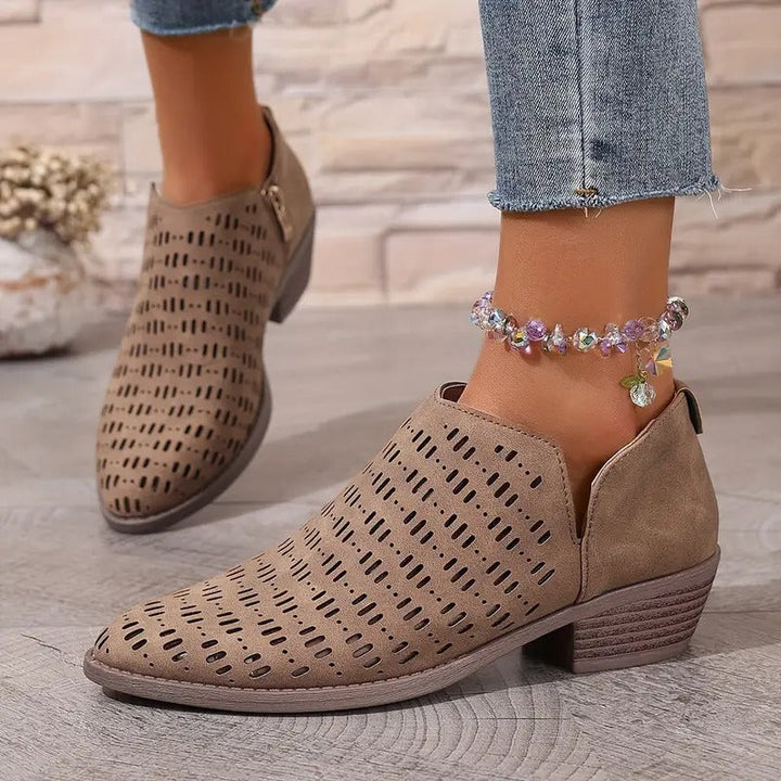 Beigefarbene Damen-Stiefeletten mit Cut-Out-Muster, seitlichem Reißverschluss und niedrigem Blockabsatz.