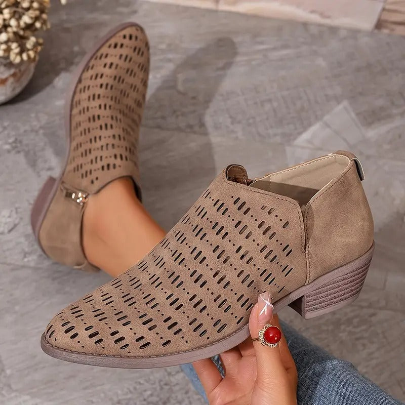 Beigefarbene Damen-Stiefeletten mit Cut-Out-Muster, spitzer Front, seitlichem Reißverschluss und niedrigem Blockabsatz.
