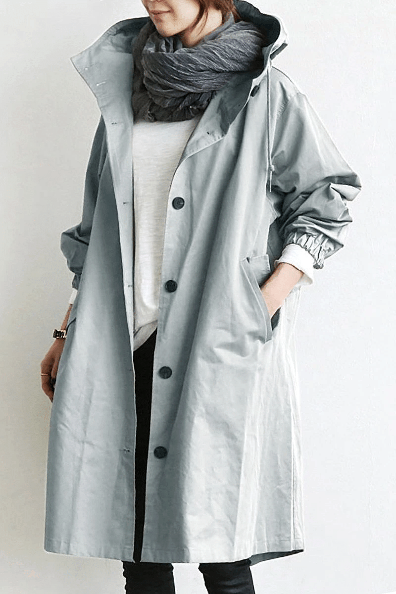 Graue, lange Oversized-Windjacke mit Kapuze, Knopfleiste und elastischen Ärmelbündchen für Damen.