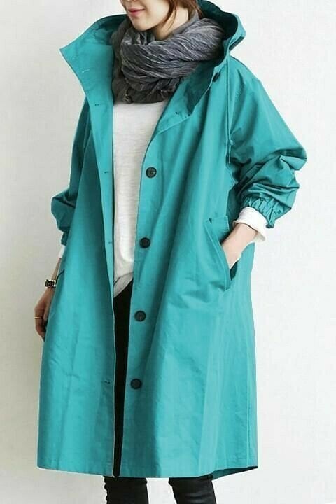 Türkisfarbene, lange Oversized-Windjacke mit Kapuze, Knopfleiste und elastischen Ärmelbündchen.