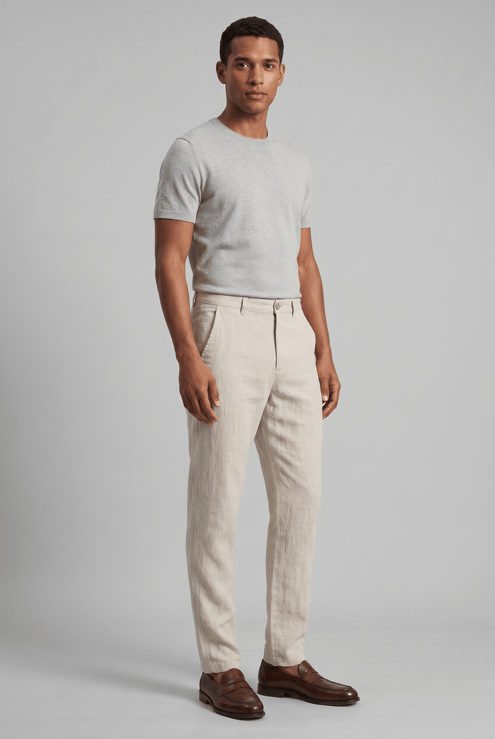 Beiger Slim Fit Leinen-Chino für Herren mit flachem Bund, kombiniert mit einem grauen T-Shirt und braunen Lederschuhen.