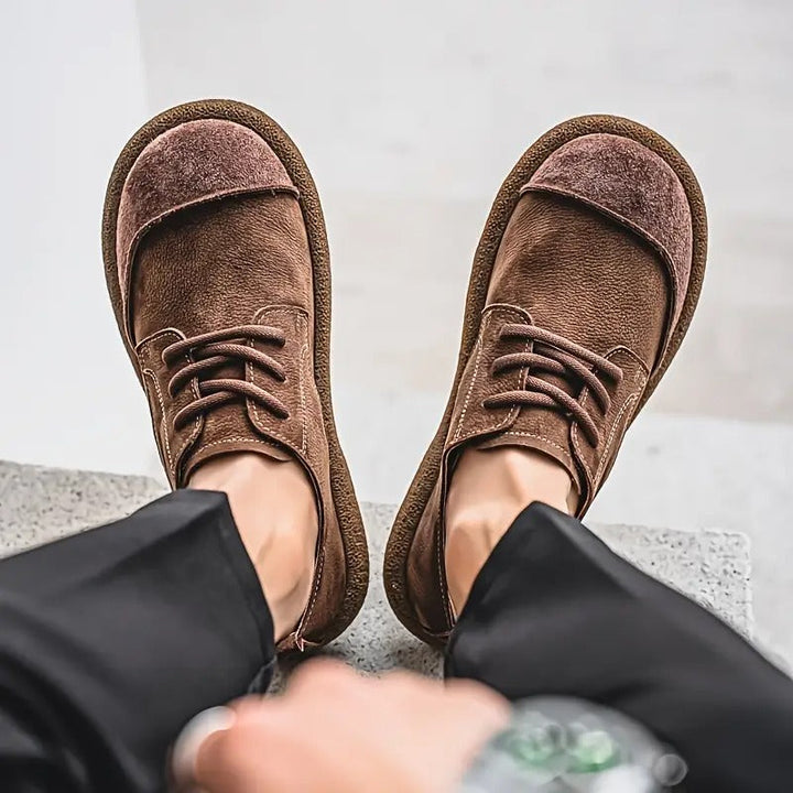 Braune Theo Herren-Schnürschuhe aus strukturiertem Leder mit abgesetzter Kappe und robuster, profilierter Laufsohle.