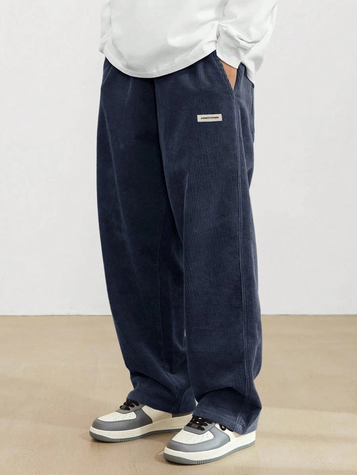 Dunkelblaue Herren-Cordhose im weiten Schnitt mit elastischem Bund und praktischen Seitentaschen für lässigen Komfort.