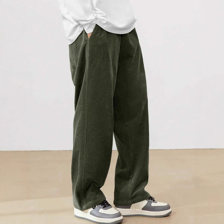 Dunkelgrüne Herren-Cordhose mit weitem Schnitt, elastischem Bund und praktischen Seitentaschen für einen lässigen Look.