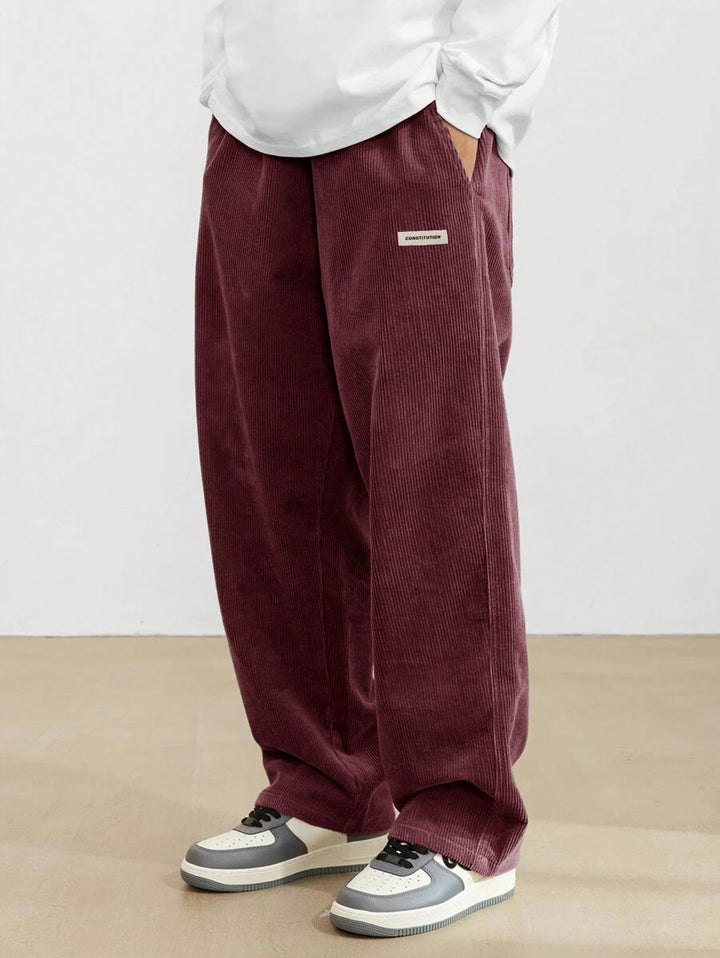 Dunkelrote Herren-Cordhose mit weitem Schnitt, elastischem Bund und praktischen Seitentaschen für einen lässigen Look.