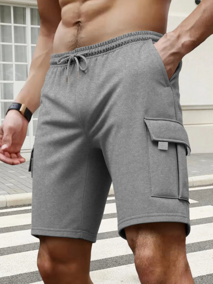 Graue Herren-Cargoshorts mit elastischem Kordelzugbund und aufgesetzten Seitentaschen aus bequemem Funktionsstoff.