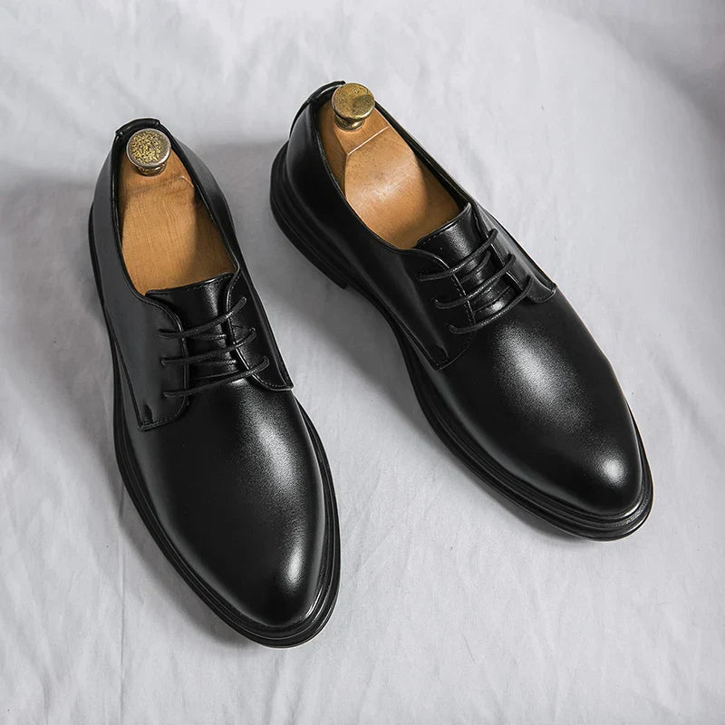 Schwarze Herren Derby-Schuhe aus glattem Leder mit klassischer Schnürung und schlanker, spitz zulaufender Silhouette.
