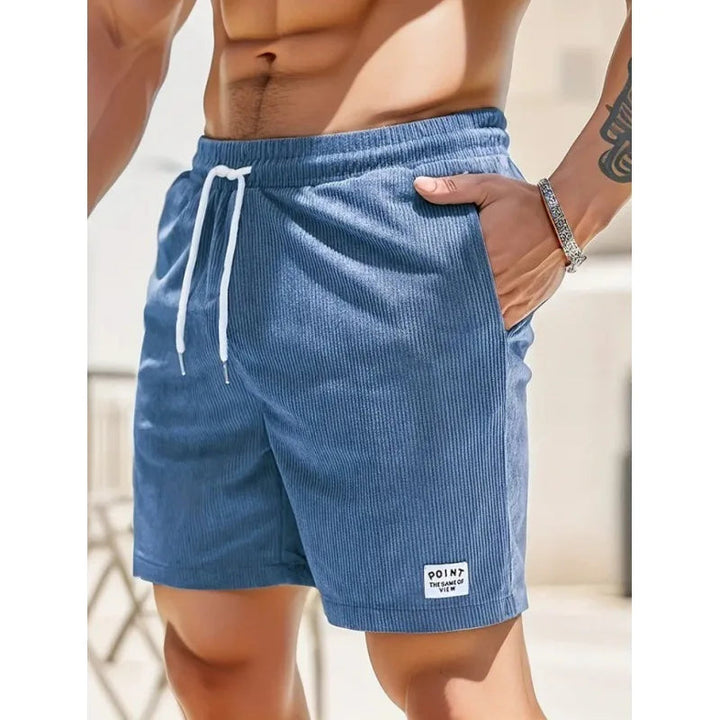 Blaue Kordelzug-Shorts aus geripptem Stoff mit weißem Kordelzug, Seitentaschen und kleinem Logo-Patch am Saum.