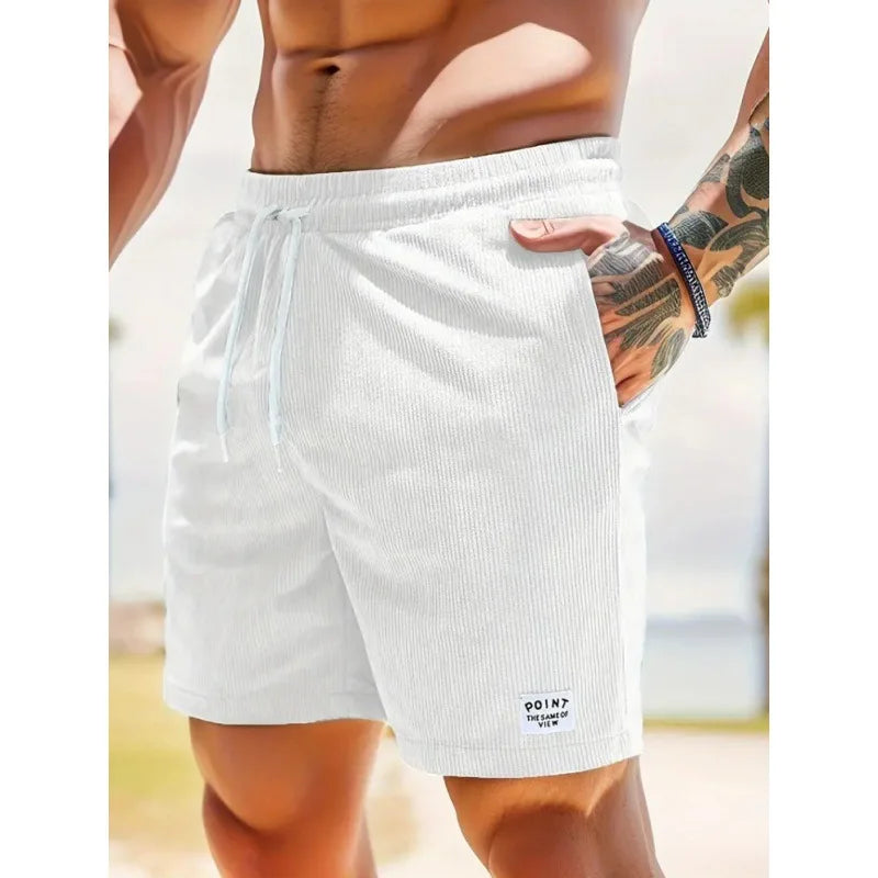Weiße Herren-Shorts mit Kordelzug, gerippter Textur, seitlichen Taschen und kleinem Logo-Patch am Saum.