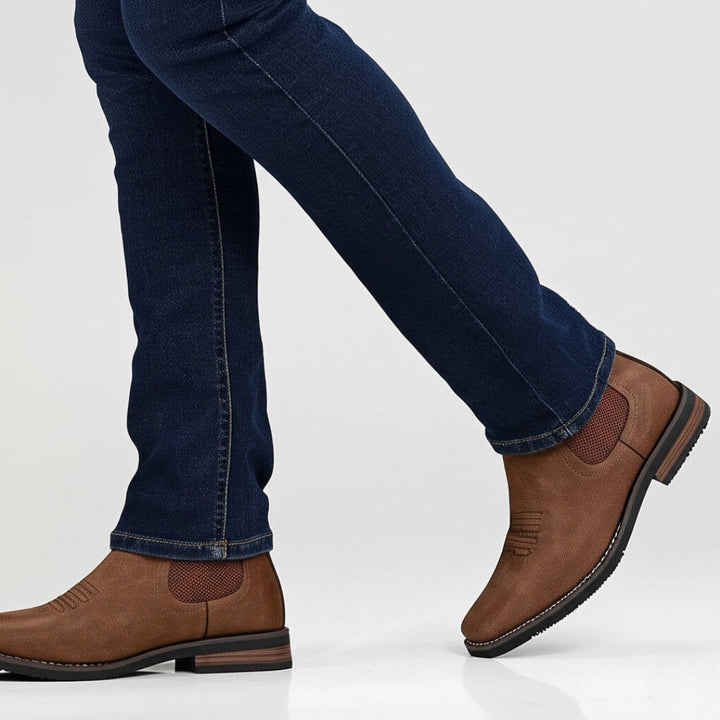 Braune Herren-Chelsea-Boots im Western-Look aus Kunstleder mit Blockabsatz und elastischen Seiteneinsätzen.