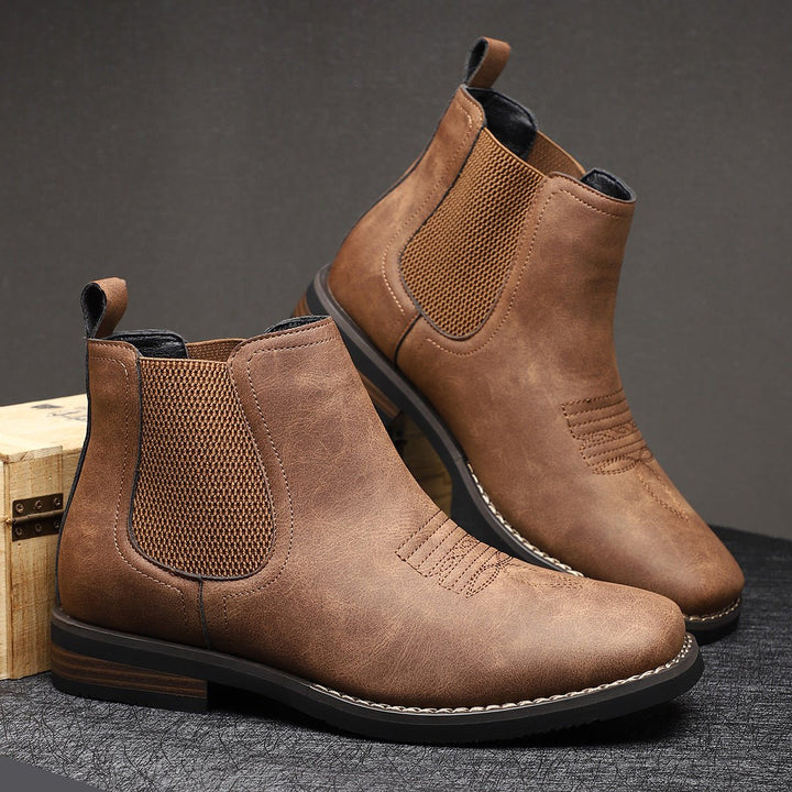 Braune Herren Chelsea Boots in Used-Optik mit elastischen Einsätzen, Zuglasche und markanten Western-Ziernähten.