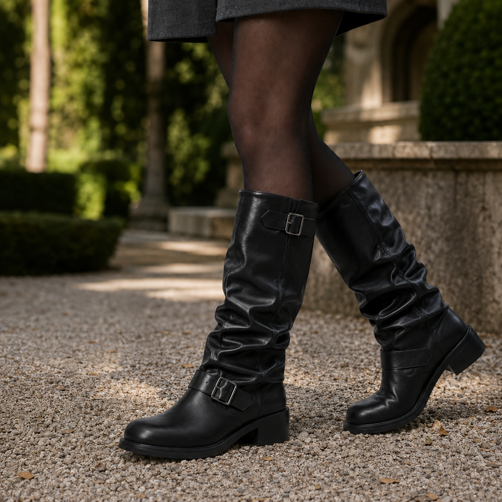 Kniehohe schwarze Bikerboots in Lederoptik mit gerafftem Schaft, silbernen Schnallen und bequemem Blockabsatz.