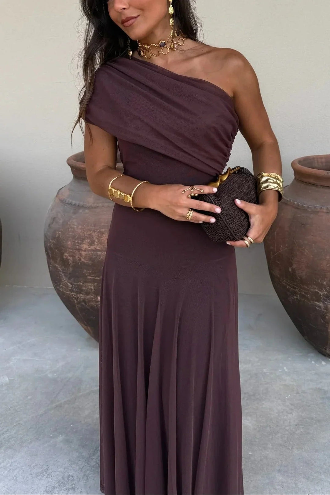 Dunkelbraunes One-Shoulder Maxikleid mit gerafftem Oberteil und fließendem Rock aus leichtem Stoff.
