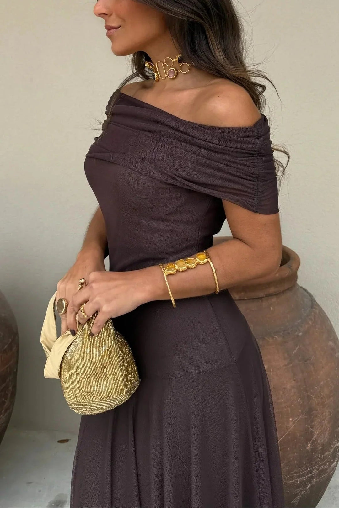 Dunkelbraunes One-Shoulder Maxikleid mit gerafftem Oberteil und fließendem Stoff für einen eleganten Look.