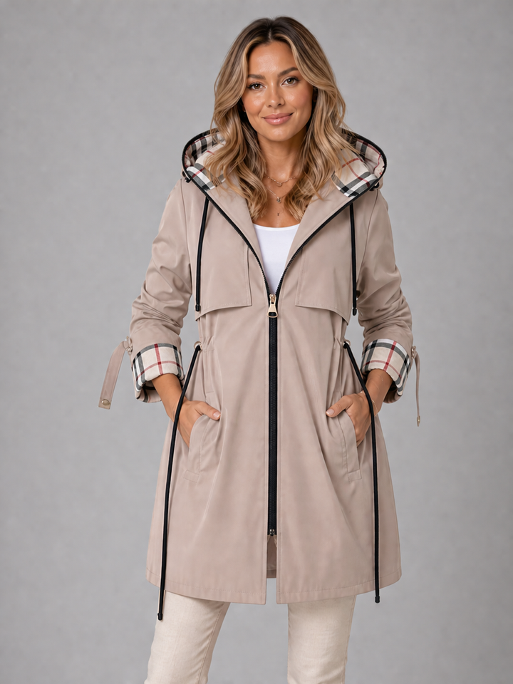 Beigefarbene Damenjacke mit Kapuze, Taillenkordelzug und eleganten karierten Akzenten an Ärmeln und Kapuze.