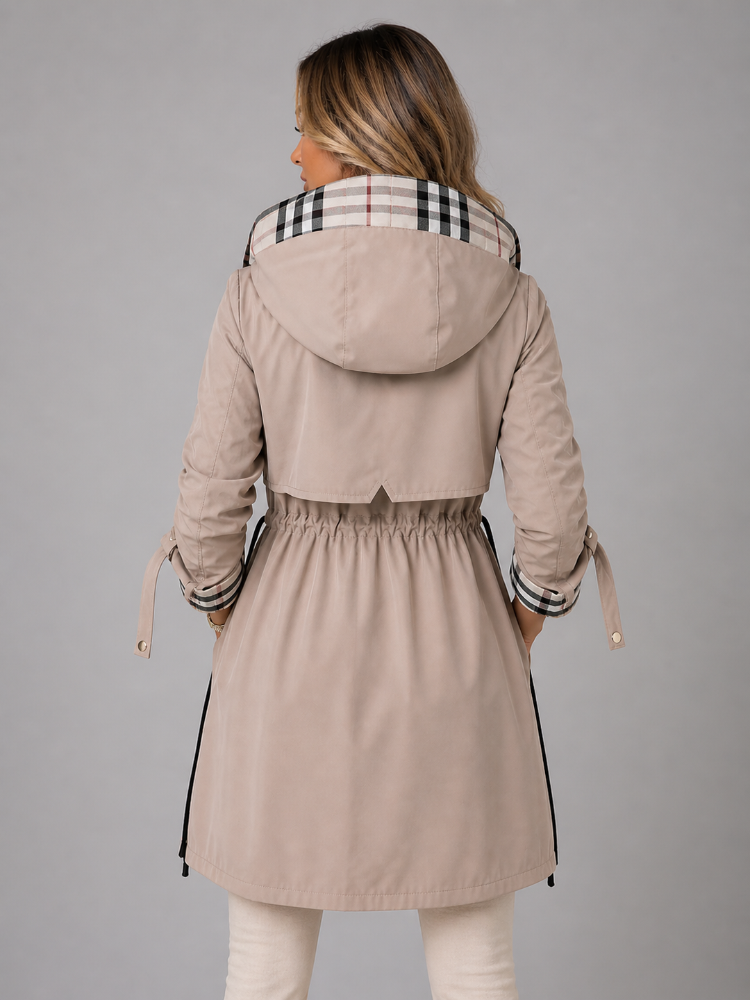 Beigefarbene Damenjacke mit Kapuze, Taillenkordelzug und eleganten karierten Akzenten an Kapuze und Ärmelaufschlägen.
