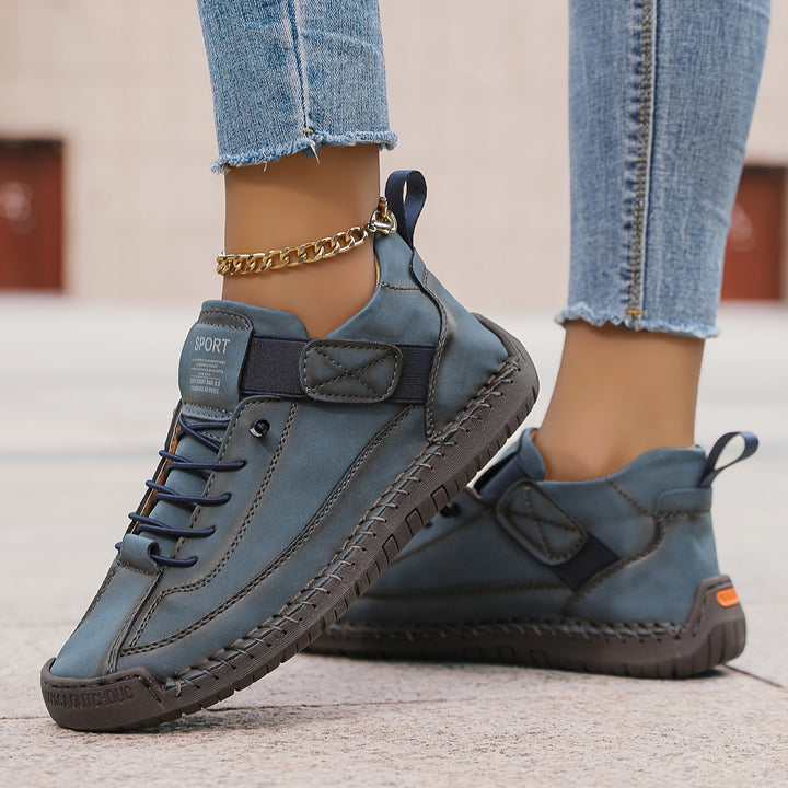 Blaue Damen-Sneaker mit Schnürung, Klettverschluss, markanten Ziernähten und flacher, profilierter Sohle.